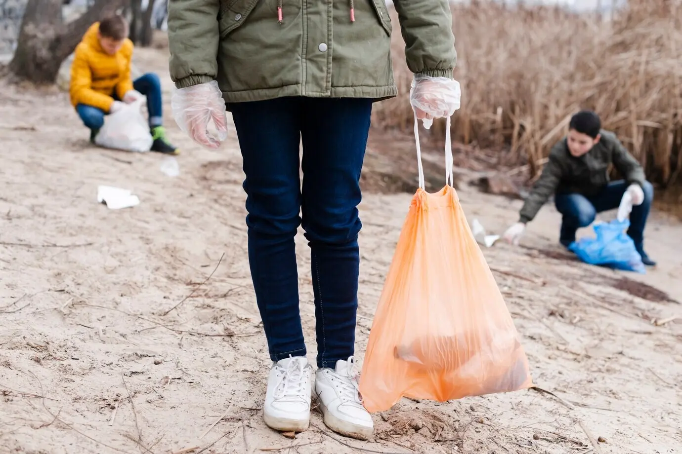 Kinder, die den Boden säubern und recyceln.